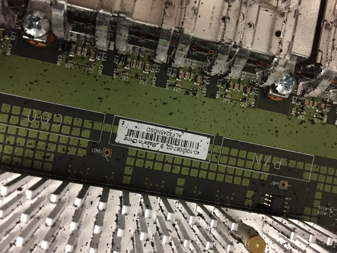 Ruß auf einer Platine nach einem Brandschaden. Rußflecken mit Trocknen, Absaugen, Hausmittel und Spülmittel aus dem Haushalt putzen und waschen.